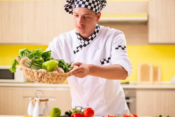 Joven cocinero profesional preparando ensalada en la cocina —  Fotos de Stock