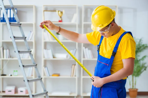 Jovem empreiteiro fazendo obras de reparação no escritório — Fotografia de Stock