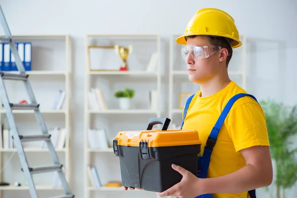 Joven contratista haciendo trabajos de reparación en la oficina —  Fotos de Stock