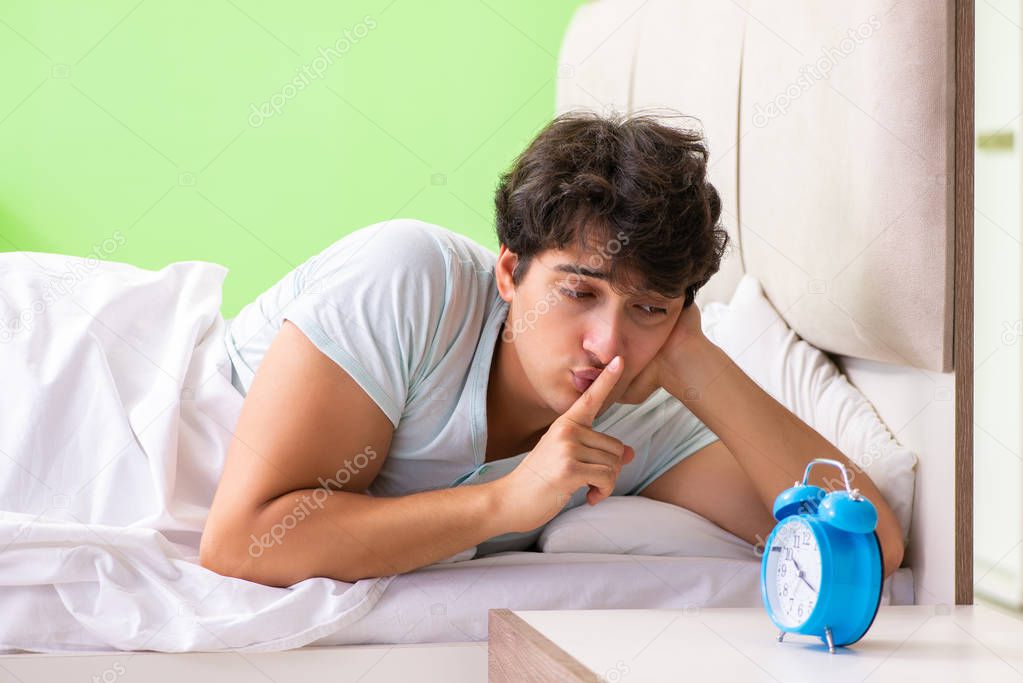 Young man having trouble waking up in early morning