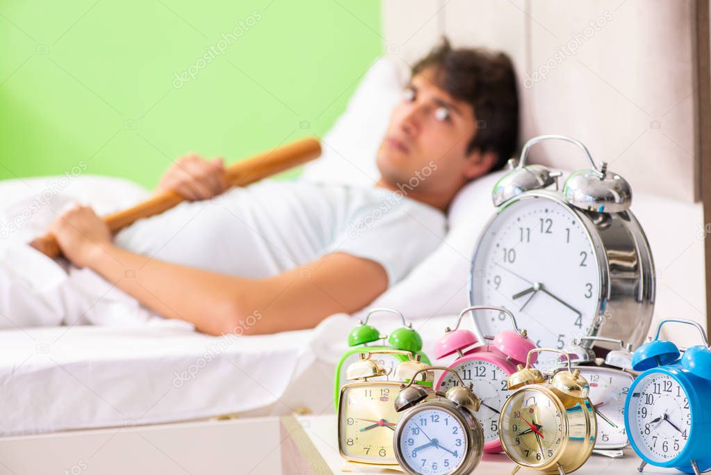 Young man having trouble waking up in early morning