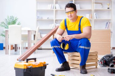 Genç müteahhit ofiste tamirat yapıyor. 