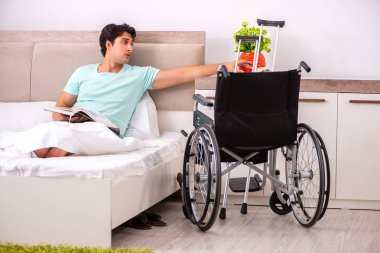 Genç yakışıklı engelli adam evde iyileşiyor. 