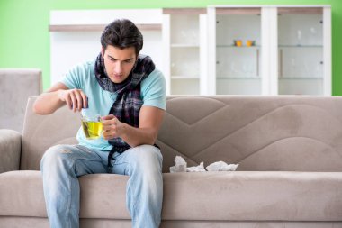 Evde hastalıktan muzdarip genç yakışıklı bir adam. 