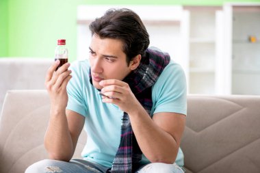 Evde hastalıktan muzdarip genç yakışıklı bir adam. 