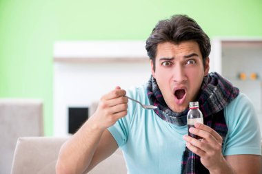 Evde hastalıktan muzdarip genç yakışıklı bir adam. 