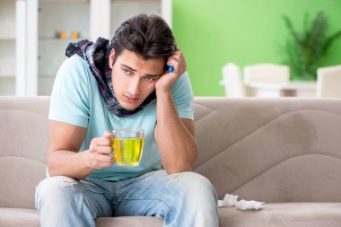 Evde hastalıktan muzdarip genç yakışıklı bir adam. 