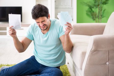 Genç adam kişisel finans ve faturalarla boğuşuyor.