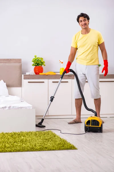 Young handsome man cleaning in the bedroom — Stock Photo, Image