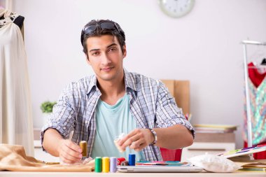 Atölyesinde çalışan yakışıklı bir terzi.