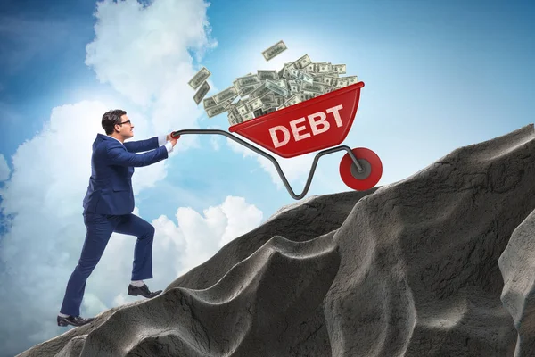 Biznesmen pchanie taczki pod górę w koncepcji pożyczki długu — Zdjęcie stockowe
