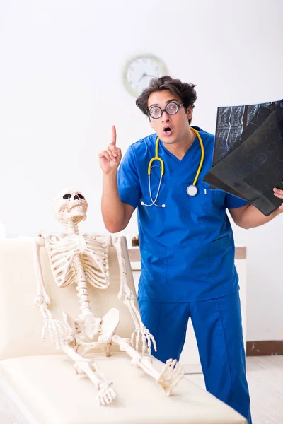 Funny doctor with skeleton in hospital — Stock Photo, Image