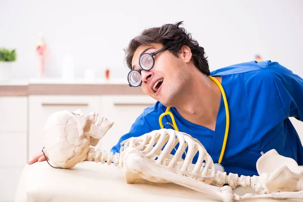 Funny doctor with skeleton in hospital — Stock Photo, Image