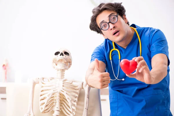 Doutor engraçado com esqueleto no hospital — Fotografia de Stock