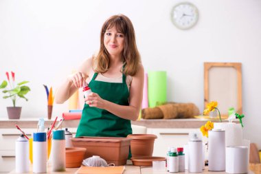 Atölyede çömlek dekore eden genç bir kadın.