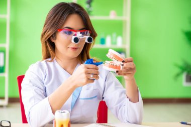 Diş implantı üzerinde çalışan kadın dişçi.