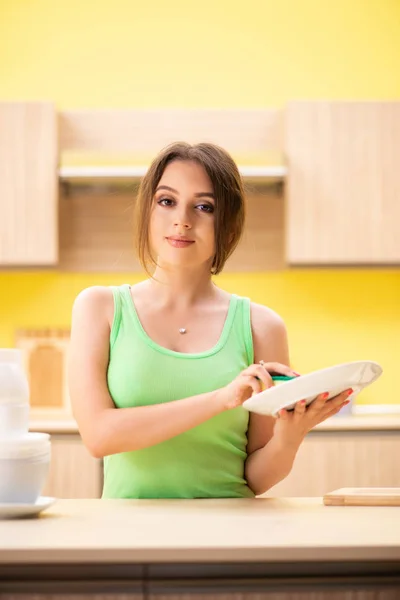 Νεαρή Γυναίκα Που Καθαρίζει Και Πλένει Πιάτα Στην Κουζίνα — Φωτογραφία Αρχείου