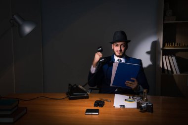 Dedektif karanlık odada klasik bir konseptle oturuyor.