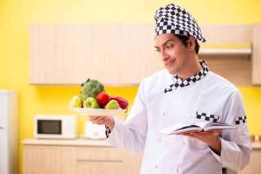 Genç profesyonel aşçı evde salata hazırlıyor.