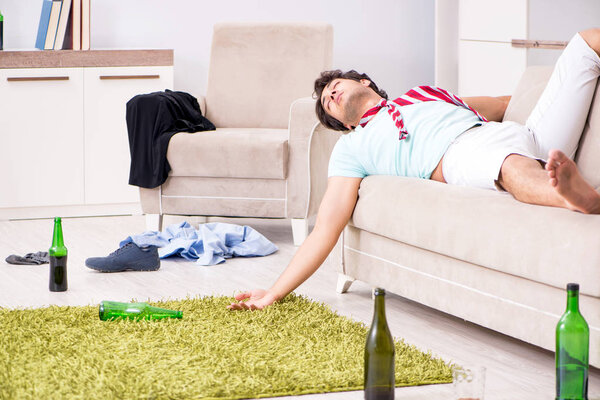 Young drunk handsome man after party at home 