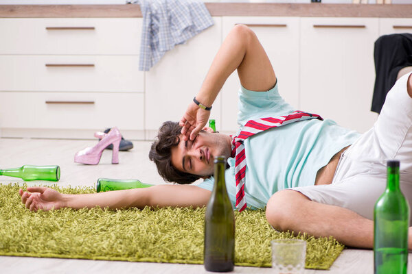 Молодой пьяный красивый мужчина после вечеринки дома 
