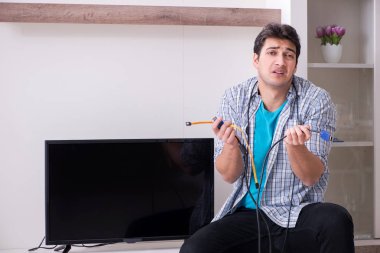 Bozuk televizyonu tamir etmeye çalışan adam