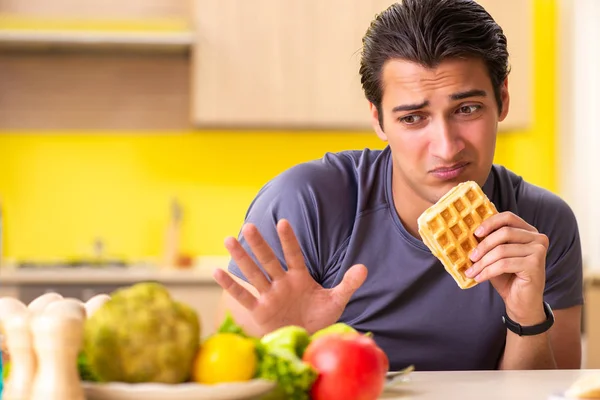 Hombre que tiene difícil elección entre la comida sana y no saludable — Foto de Stock