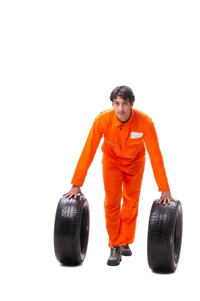 Young garage worker with tyre isolated on white — Stock Photo, Image