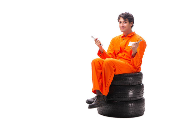 Young garage worker with tyre isolated on white