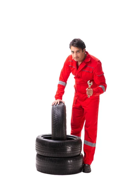 Young garage worker with tyre isolated on white — Stock Photo, Image