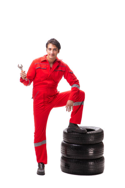 Young garage worker with tyre isolated on white