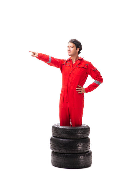 Young garage worker with tyre isolated on white