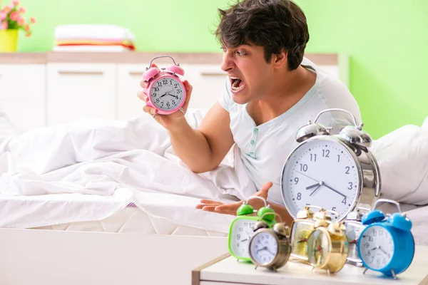 Young man having trouble waking up in early morning