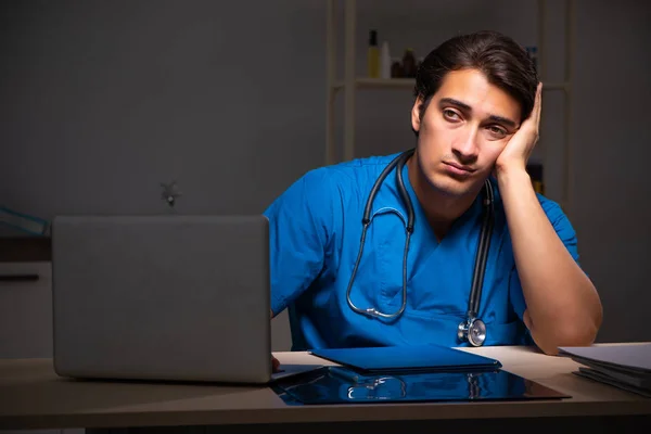 Joven médico guapo trabajando turno de noche en el hospital —  Fotos de Stock
