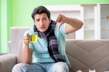 Evde hastalıktan muzdarip genç yakışıklı bir adam. 