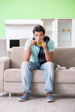 Evde hastalıktan muzdarip genç yakışıklı bir adam. 