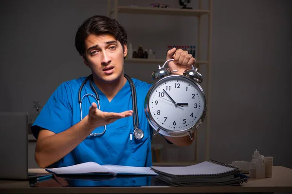 Jovem médico bonito trabalhando turno da noite no hospital — Fotografia de Stock