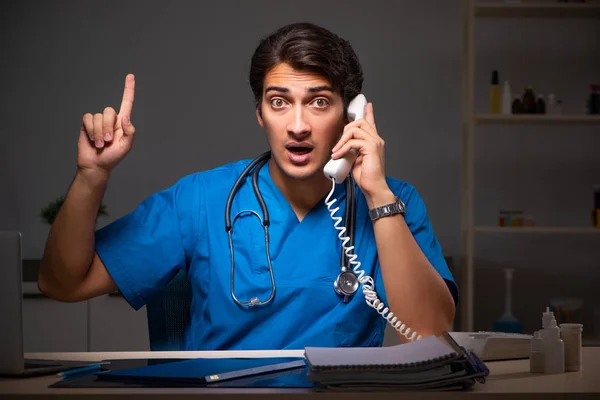 Joven médico guapo trabajando turno de noche en el hospital — Foto de Stock