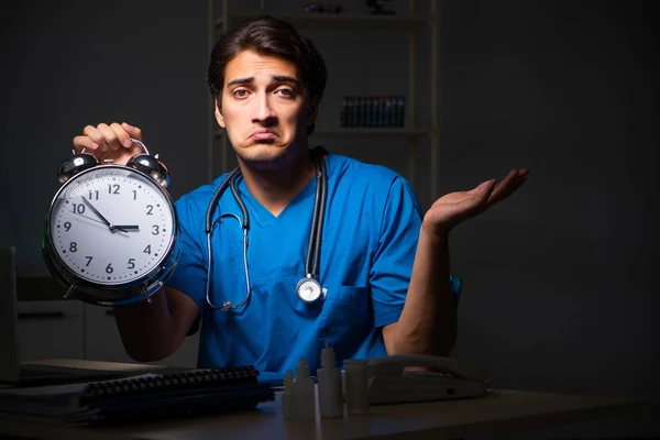 Joven médico guapo trabajando turno de noche en el hospital —  Fotos de Stock