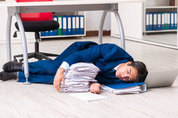 Tired exhausted businessman working overtime in office