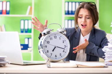 Young female employee very busy with ongoing paperwork in time management concept clipart