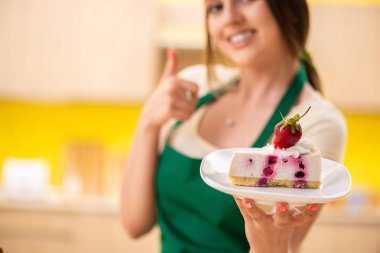 Genç aşçı mutfakta kek pişiriyor.