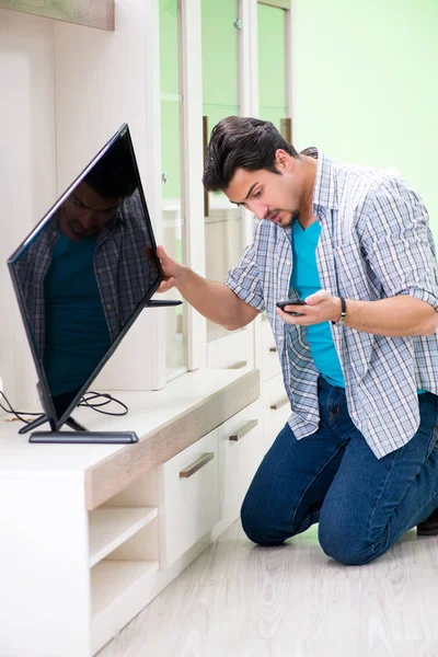 Young man husband repairing tv at home