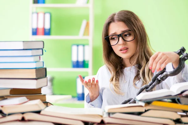 Joven estudiante encadenada al escritorio y preparándose para los exámenes — Foto de Stock