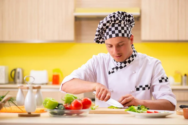 Joven cocinero profesional preparando ensalada en la cocina —  Fotos de Stock