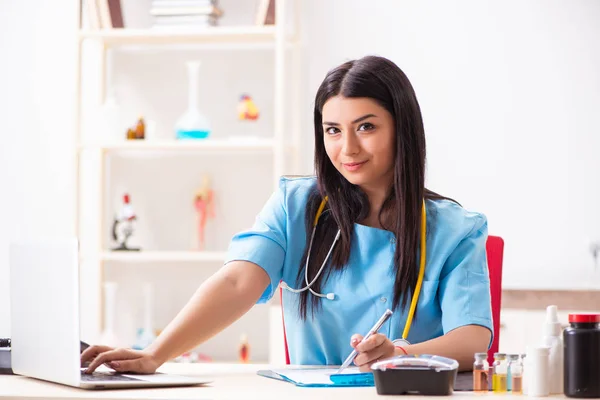 Jonge mooie vrouwelijke arts werkzaam in de kliniek — Stockfoto