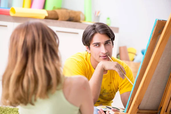 Pareja joven disfrutando de la pintura en casa — Foto de Stock