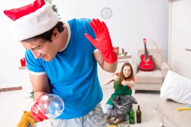 Noel partisinden sonra genç bir aile evi temizliyor.