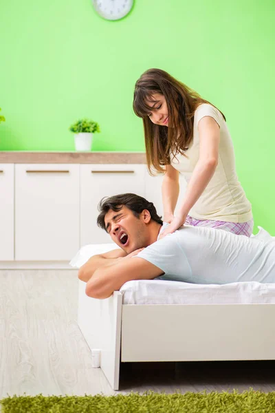 Женщина делает массаж мужу в спальне — стоковое фото