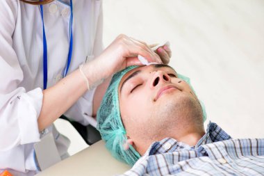 Estetik cerrah insan yüzü ameliyatına hazırlanıyor.